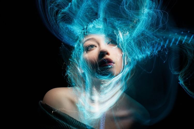 Ritratto di una donna con sguardo profondo e sfumature blu astratte