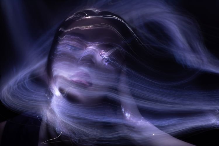 Una donna con il volto coperto da un aura speciale violetta.